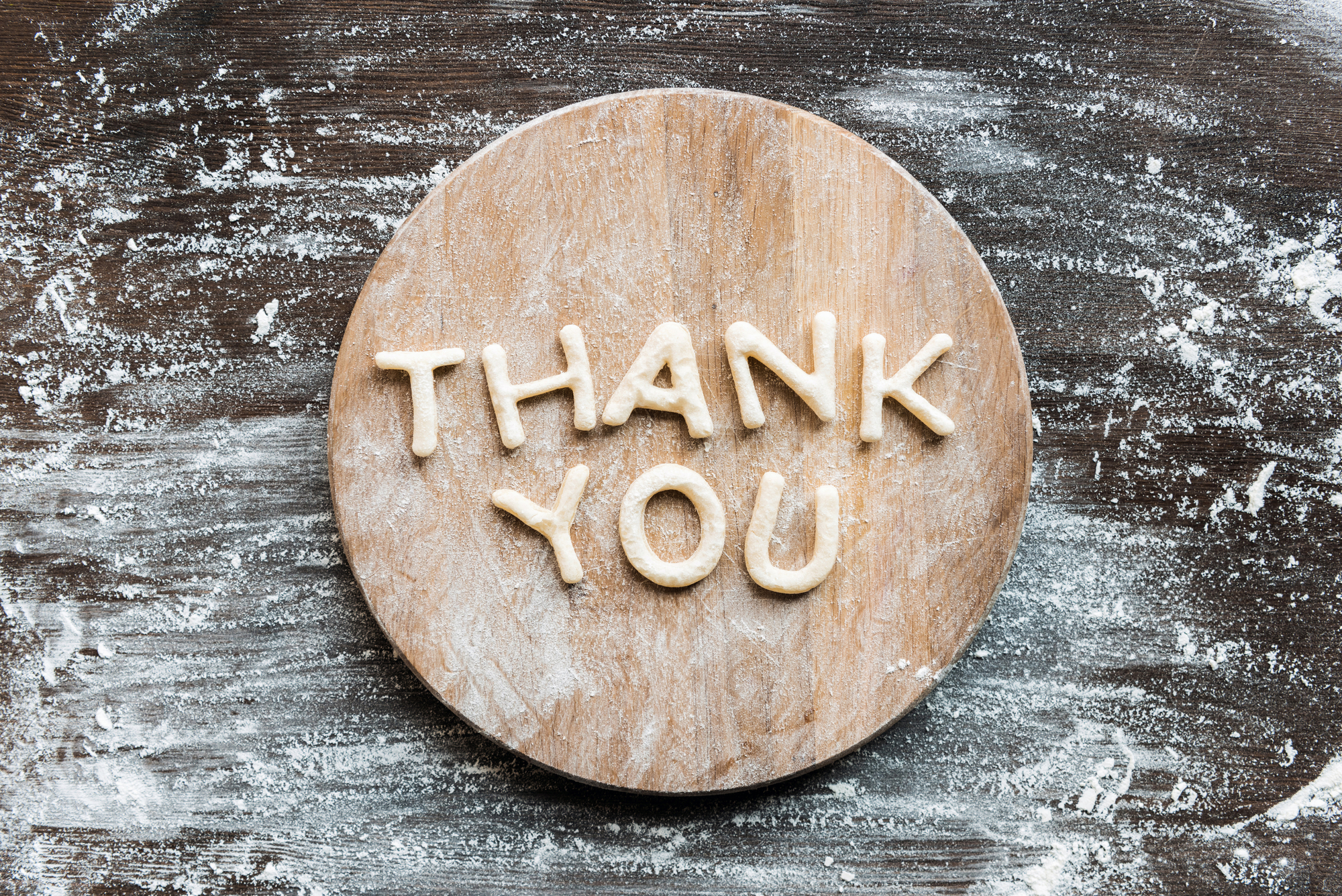 dough spelling thank you on wood cutting board